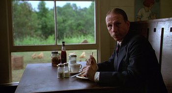 Movie still from “Fried Green Tomatoes” (1991), directed by Jon Avnet – A man sitting at a table with a plate in front of him; Close Up shot, Low angle
