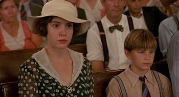 Movie still from “Fried Green Tomatoes” (1991), directed by Jon Avnet – A woman in a hat and a man in a suit sitting in a crowd; Close Up shot, Low angle