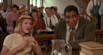 Movie still from “Fried Green Tomatoes” (1991), directed by Jon Avnet – A man and a woman sitting at a table in front of a group of people; Medium shot, Low angle