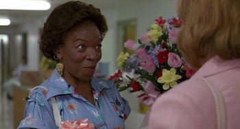 Movie still from “Fried Green Tomatoes” (1991), directed by Jon Avnet – An older black woman standing next to a bunch of flowers; Close Up shot, Over the shoulder angle