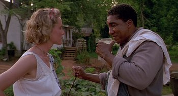Movie still from “Fried Green Tomatoes” (1991), directed by Jon Avnet – A man and a woman are holding a cup of coffee; Medium shot, Over the shoulder angle