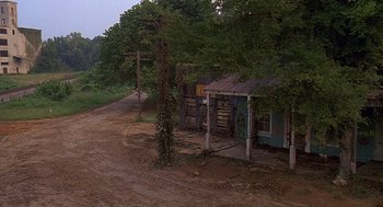 Movie still from “Fried Green Tomatoes” (1991), directed by Jon Avnet – An old house on a dirt road near a forest; Extreme Wide shot, High angle