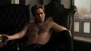 Movie still from “Fright Night” (2011), directed by Craig Gillespie – A shirtless man sitting in a black chair; Medium shot, High angle