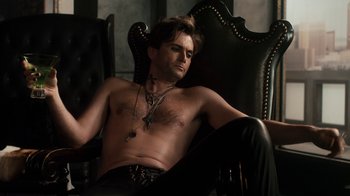 Movie still from “Fright Night” (2011), directed by Craig Gillespie – A shirtless man sitting in a black chair; Medium shot, Overhead angle
