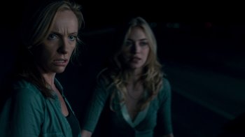 Movie still from “Fright Night” (2011), directed by Craig Gillespie – Two women standing next to each other in the dark; Medium shot, Over the shoulder angle