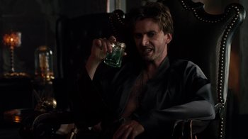 Movie still from “Fright Night” (2011), directed by Craig Gillespie – A man is holding a green liquid in his hand; Medium shot, High angle