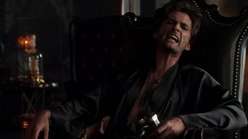 Movie still from “Fright Night” (2011), directed by Craig Gillespie – A man sitting in a chair holding a bottle of alcohol; Close Up shot, Overhead angle