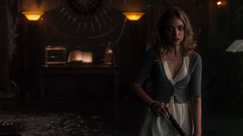 Movie still from “Fright Night” (2011), directed by Craig Gillespie – A woman holding a knife in a dark room; Medium shot, Over the shoulder angle