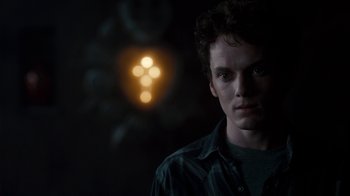 Movie still from “Fright Night” (2011), directed by Craig Gillespie – A young man is standing in front of a light; Close Up shot, Over the shoulder angle