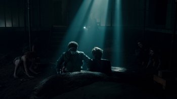 Movie still from “Fright Night” (2011), directed by Craig Gillespie – Two people sitting in a dark room under a beam of light; Wide shot, Over the shoulder angle