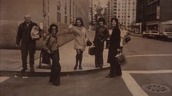 Movie still from “Fritz the Cat” (1972), directed by Ralph Bakshi – A group of women standing next to each other on a sidewalk; Wide shot, Low angle