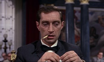 Movie still from “From Russia with Love” (1963), directed by Terence Young – A person wearing a suit holding a cigarette; Close Up shot, High angle