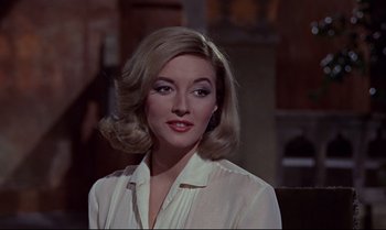 Movie still from “From Russia with Love” (1963), directed by Terence Young – A woman in a white shirt is posing for a picture; Close Up shot, Over the shoulder angle