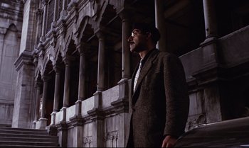 Movie still from “From Russia with Love” (1963), directed by Terence Young – A man standing in front of a tall building; Wide shot, Low angle