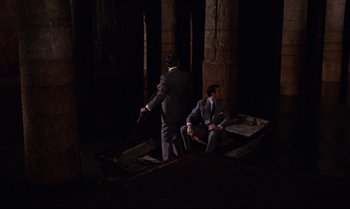 Movie still from “From Russia with Love” (1963), directed by Terence Young – Two men in suits and ties sitting on a boat in the dark; Wide shot, High angle