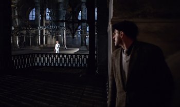 Movie still from “From Russia with Love” (1963), directed by Terence Young – A man in a suit standing in front of a building; Wide shot, Over the shoulder angle