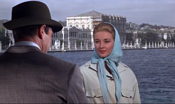 Movie still from “From Russia with Love” (1963), directed by Terence Young – A man and a woman standing next to each other near a body of water; Medium shot, Over the shoulder angle