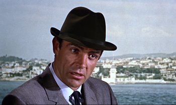 Movie still from “From Russia with Love” (1963), directed by Terence Young – A person wearing a suit and a hat; Close Up shot, Low angle
