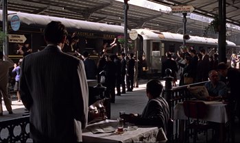 Movie still from “From Russia with Love” (1963), directed by Terence Young – A group of people standing on a train platform next to a train; Extreme Wide shot, High angle