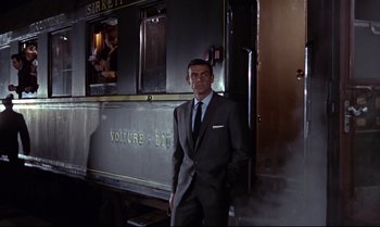 Movie still from “From Russia with Love” (1963), directed by Terence Young – A man standing in front of a train car; Wide shot, Low angle