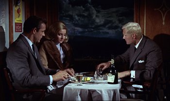 Movie still from “From Russia with Love” (1963), directed by Terence Young – A group of people sitting at a dinner table; Medium shot, High angle