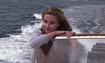 Movie still from “From Russia with Love” (1963), directed by Terence Young – A beautiful young woman riding a boat on top of a body of water; Medium shot, High angle