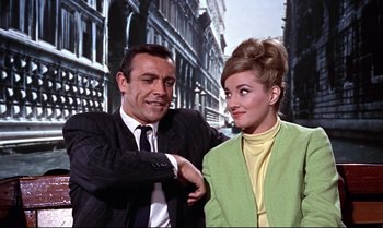 Movie still from “From Russia with Love” (1963), directed by Terence Young – A man and a woman standing next to each other in front of a building; Medium shot, Low angle