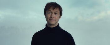 Movie still from “The Walk” (2015), directed by Robert Zemeckis – A man in a black shirt is smiling for the camera; Close Up shot, Low angle
