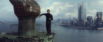 Movie still from “The Walk” (2015), directed by Robert Zemeckis – A man standing on top of a building near the water; Wide shot, Low angle
