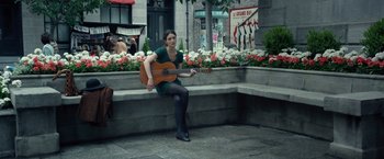 Movie still from “The Walk” (2015), directed by Robert Zemeckis – A woman sitting on a bench with a guitar; Wide shot, Over the shoulder angle