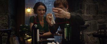 Movie still from “The Walk” (2015), directed by Robert Zemeckis – A man and a woman sitting at a table with wine glasses; Medium shot, Over the shoulder angle