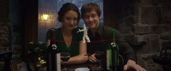 Movie still from “The Walk” (2015), directed by Robert Zemeckis – A man and a woman sitting at a table with wine glasses; Close Up shot, Over the shoulder angle