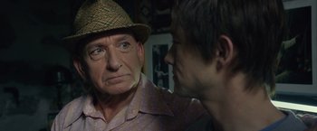 Movie still from “The Walk” (2015), directed by Robert Zemeckis – An older man wearing a straw hat talking to a younger man; Close Up shot, Over the shoulder angle