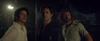 Movie still from “The Walk” (2015), directed by Robert Zemeckis – Two men standing next to each other in a dark room; Medium shot, Low angle