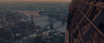 Movie still from “The Walk” (2015), directed by Robert Zemeckis – A man standing on the side of a building on a bridge; Extreme Wide shot, Overhead angle