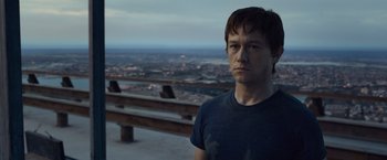 Movie still from “The Walk” (2015), directed by Robert Zemeckis – A man standing on top of a building looking at the camera; Close Up shot, Over the shoulder angle