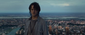 Movie still from “The Walk” (2015), directed by Robert Zemeckis – A man standing on top of a building in front of a city; Close Up shot, Over the shoulder angle