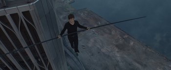 Movie still from “The Walk” (2015), directed by Robert Zemeckis – A man walking on a metal wire over a body of water; Wide shot, High angle
