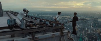 Movie still from “The Walk” (2015), directed by Robert Zemeckis – A man standing on top of a wooden structure on top of a building; Extreme Wide shot, High angle
