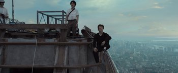 Movie still from “The Walk” (2015), directed by Robert Zemeckis – Two men are standing on the top of a building; Wide shot, Low angle
