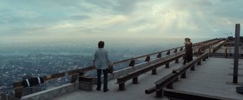 Movie still from “The Walk” (2015), directed by Robert Zemeckis – A woman standing on a balcony looking at a city; Extreme Wide shot, High angle
