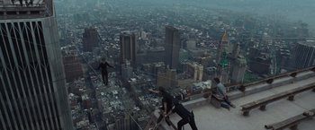 Movie still from “The Walk” (2015), directed by Robert Zemeckis – A group of people standing on top of a building looking out over a city; Extreme Wide shot, High angle