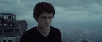 Movie still from “The Walk” (2015), directed by Robert Zemeckis – A young man with short black hair stares into the distance; Close Up shot, Low angle
