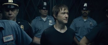 Movie still from “The Walk” (2015), directed by Robert Zemeckis – A man standing in front of a group of police officers; Close Up shot, Over the shoulder angle