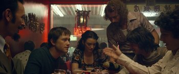 Movie still from “The Walk” (2015), directed by Robert Zemeckis – A group of people sitting at a table in a restaurant; Medium shot, Over the shoulder angle