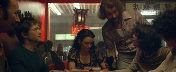 Movie still from “The Walk” (2015), directed by Robert Zemeckis – A man and a woman sitting at a dinner table; Medium shot, Over the shoulder angle