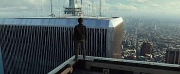 Movie still from “The Walk” (2015), directed by Robert Zemeckis – A man standing on top of a building looking at the sky; Extreme Wide shot, High angle