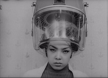 A woman with a hair dryer on top of her head