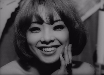 A black - and - white photo of a woman smiling for the camera
