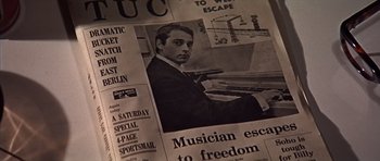 Movie still from “Funeral in Berlin” (1966), directed by Guy Hamilton – A newspaper with a picture of a man playing the piano; Extreme Close Up shot, Overhead angle